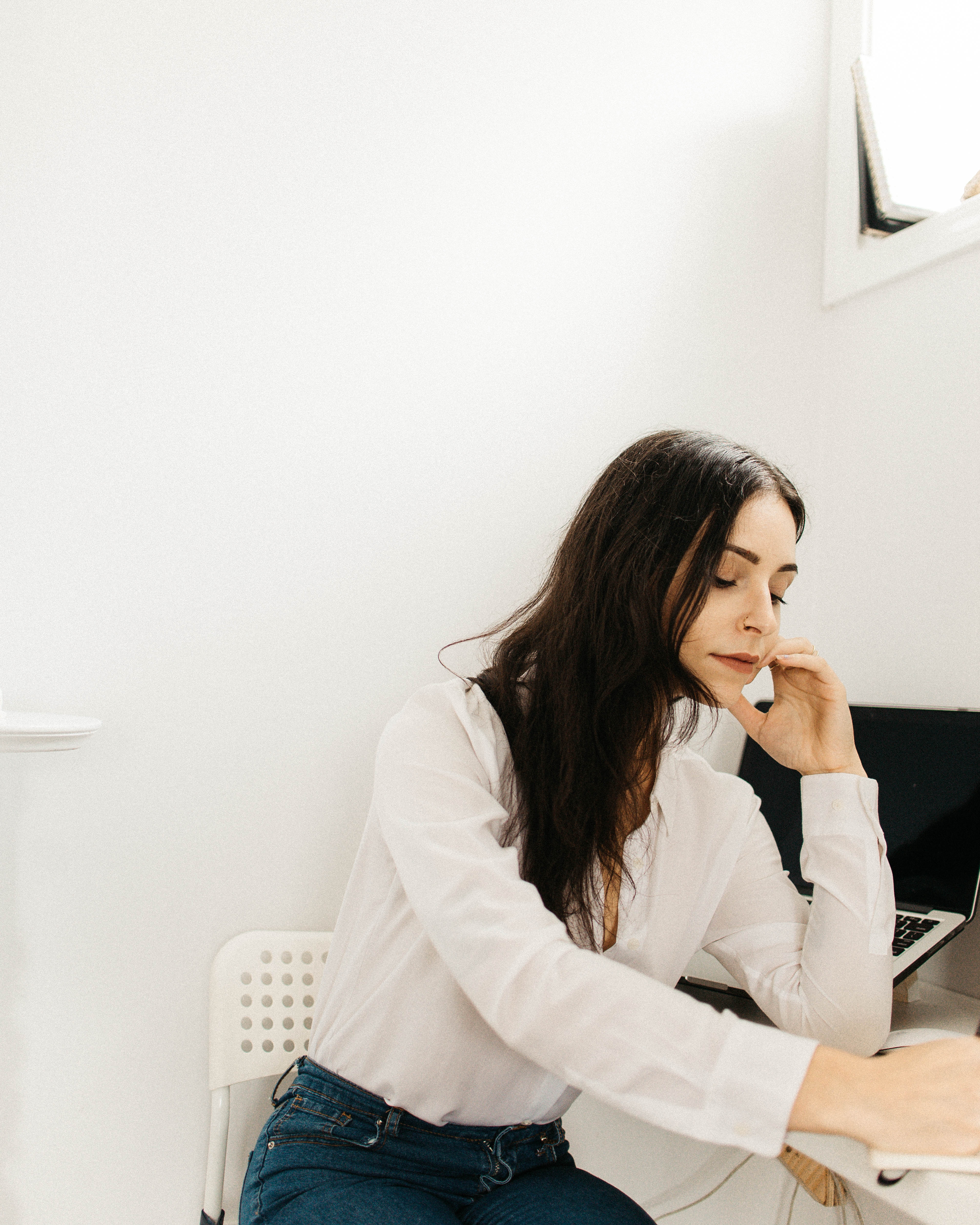 A woman sitting at a desk, working on a laptop